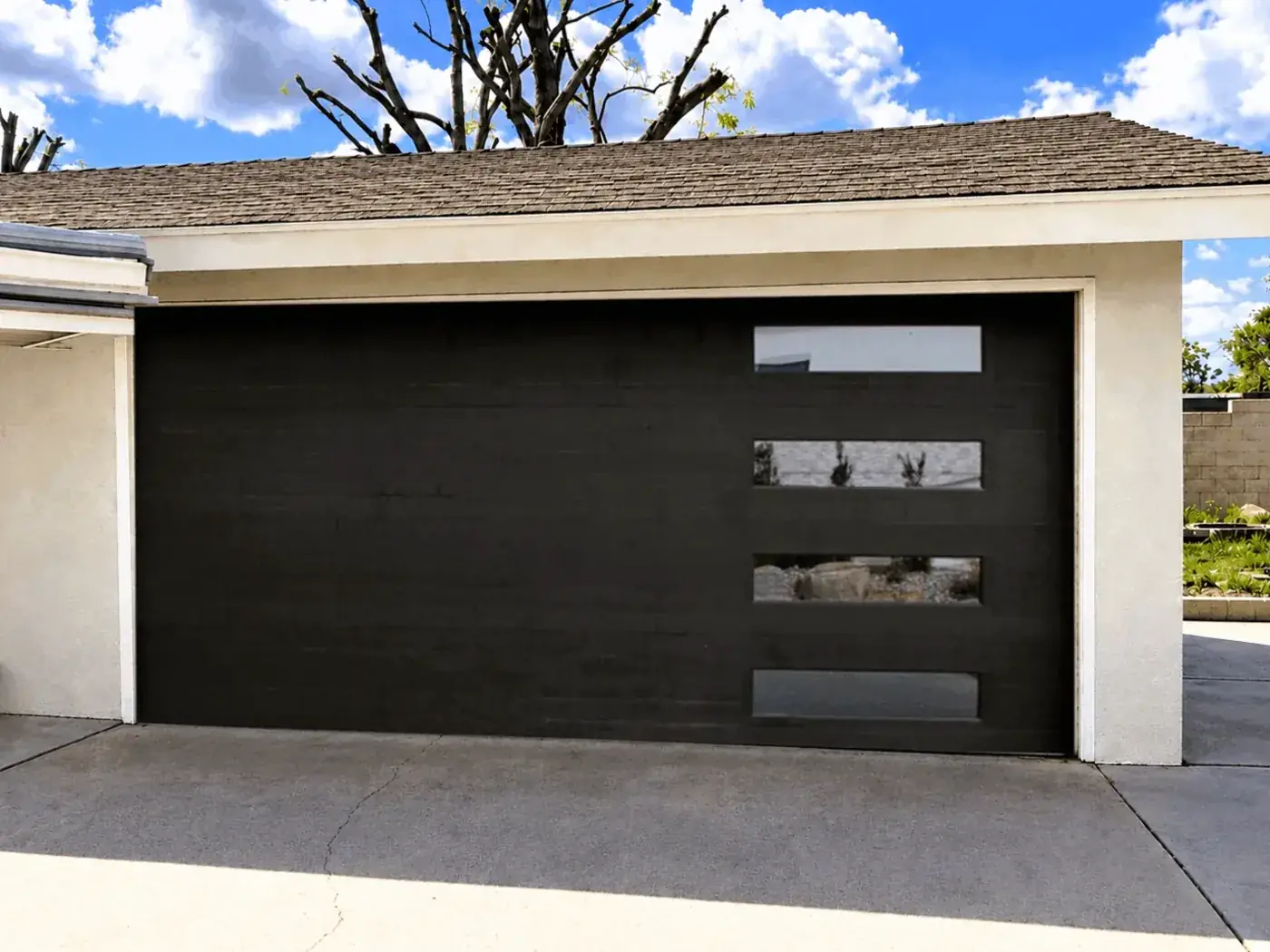 After, new modern black garage door with window panels.